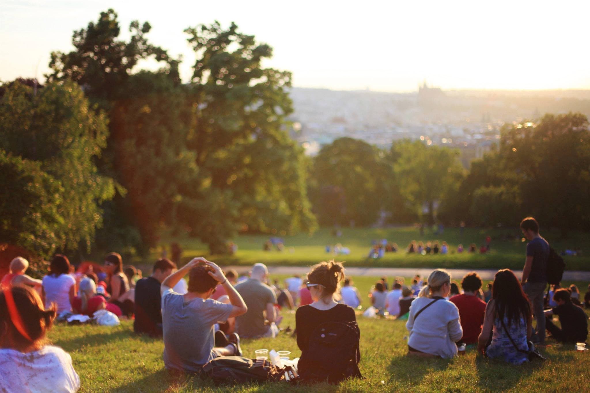 people gathered in a park sitting and enjoying the scenery 